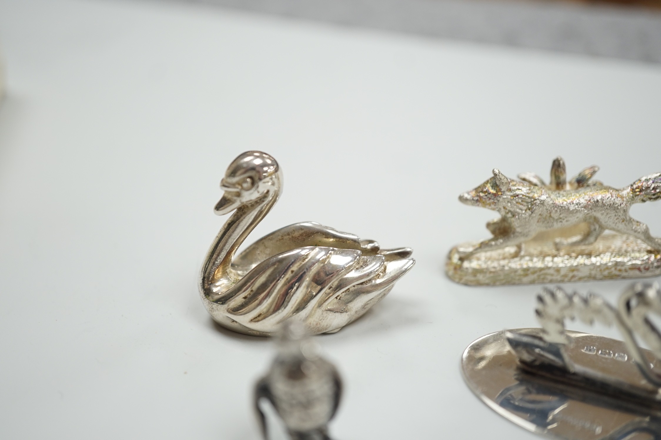 Eight assorted modern silver miniature animal or bird figures including menu holders, including rabbit by Tessiers Ltd, height 27mm, an earlier silver swan menu holder and a silver gilt owl brooch.